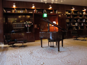 photo of the lounge with bookcase and piano at mr. c hotel beverly hills